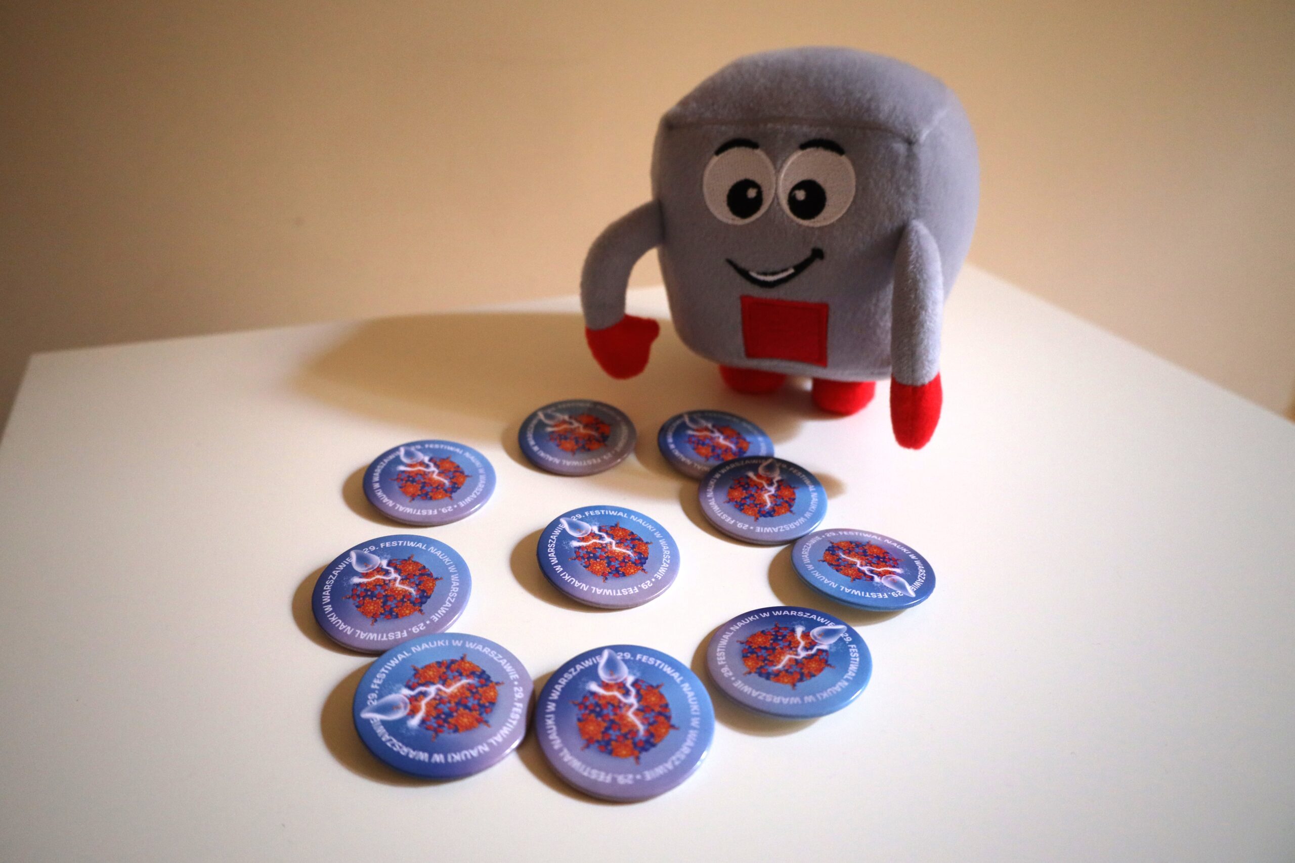 Na kolorowym zdjęciu widać pluszaka z dziesięcioma przypinkami.