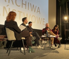 Dr Paweł Pietrzyk – Naczelny Dyrektor Archiwów Państwowych, Kamil Polak, Radosław Ładczuk, Hugh Welchman i Katarzyna Głuchowska – tłumaczka, fot. M. Frontczak Dwie kobiety i trzech mężczyzn siedzących przy stoliku w trakcie dyskusji. W tle ekran z logo Archiwów Państwowych.