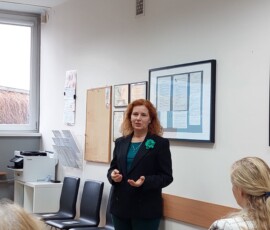 Fotografia kobiety w rudych włosach w trakcie wystąpienia.