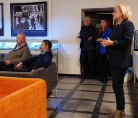 Kolorowa fotografia ludzi siedzących i słuchających prelegentki.