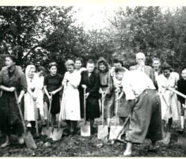 Porządkowanie ogródka jordanowskiego przy ul. Słowackiego 45, wrzesień 1947 r. Na czarno-białej fotografii widać piętnaście osób z łopatami, na tle drzewa.