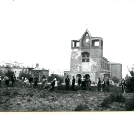 Porządkowanie ogródka jordanowskiego przy ul. Kozietulskiego, wrzesień 1947 r. Na czarno-białej fotografii widać grupę ludzi wbijających łopaty w ziemię, w tle budynek kościoła i kilka innych budynków.