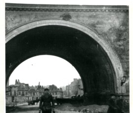 Fragment wiaduktu Pancera – w głębi plac Mariensztacki, styczeń 1948 r. Na czarno-białej fotografii widać fragment wiaduktu i mężczyznę idącego wzdłuż torów, obok dwaj inni spacerujący mężczyźni.