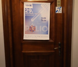 Plakat 29. Festiwalu Nauki w Warszawie na drzwiach czytelni Archiwum Państwowego w Warszawie Na kolorowym zdjęciu widać plakat i plakietki na drzwiach