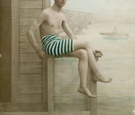 Portret Wacława Nowakowskiego na tle Wisły i Mostu Kierbedzia, 1917 r., Dar Elżbiety Nowakowskiej, Archiwum Państwowe w Warszawie, sygn. 72/3882/0/33/1749. Czarno-biała fotografia ukazująca młodego chłopca w szortach w zielone paski, w tle widać most i statek na wodzie.